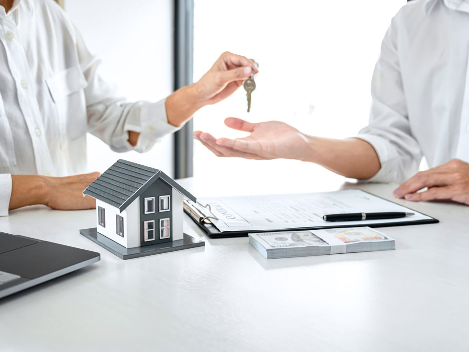 Immobilie erfolgreich verkaufen | Ein Haustürschlüssel wird nach Vertragsunterzeichnung übergeben