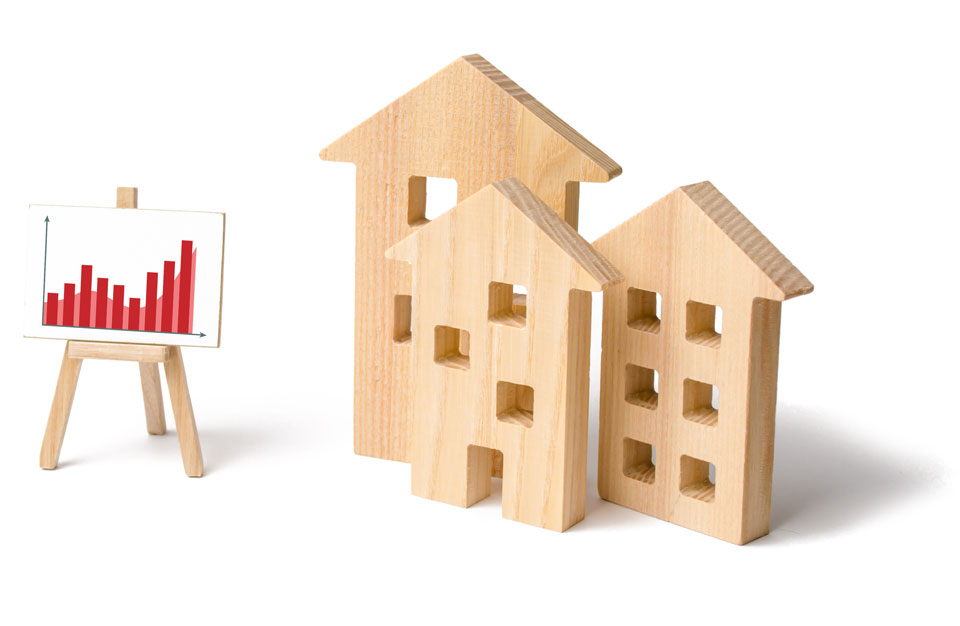 Drei stilisierte Holzhäuser und ein Schaubrett mit einem roten Balkendiagramm, das einen steigenden Trend darstellt